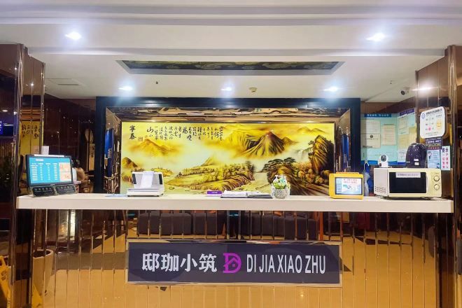 Balcão de recepção com uma placa que diz 'DIJIA XIAO ZHU'.