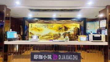 Balcão de recepção com uma placa que diz 'DIJIA XIAO ZHU'.