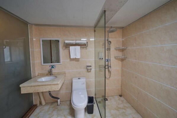 A bathroom with a glass-enclosed shower, a toilet, and a sink with a mirror above it.