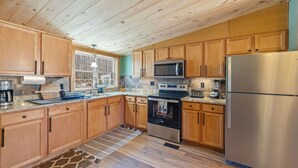 A kitchen with wooden cabinets, a stainless steel refrigerator, a microwave, an oven, and a sink. - Peaceful Escape | Dock Option + Fire pit | Winni (Moultonborough)