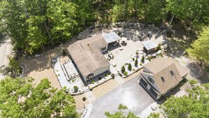 A residential property with two houses, a stone wall, and a paved driveway. - Peaceful Escape | Dock Option + Fire pit | Winni (Moultonborough)