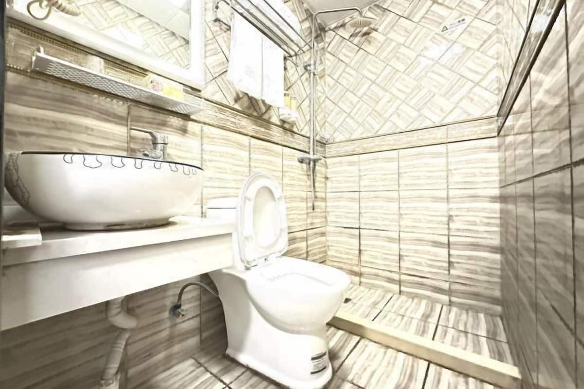 A bathroom with a white sink, a toilet, and a shower area.