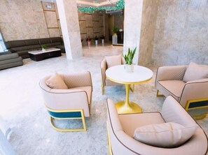 A lobby with a round table and two sofas, a dark-colored sofa, and a plant on the table. - Longqiao Hotel (Yichang Yiting Three Gorges Airport) (Yichang)