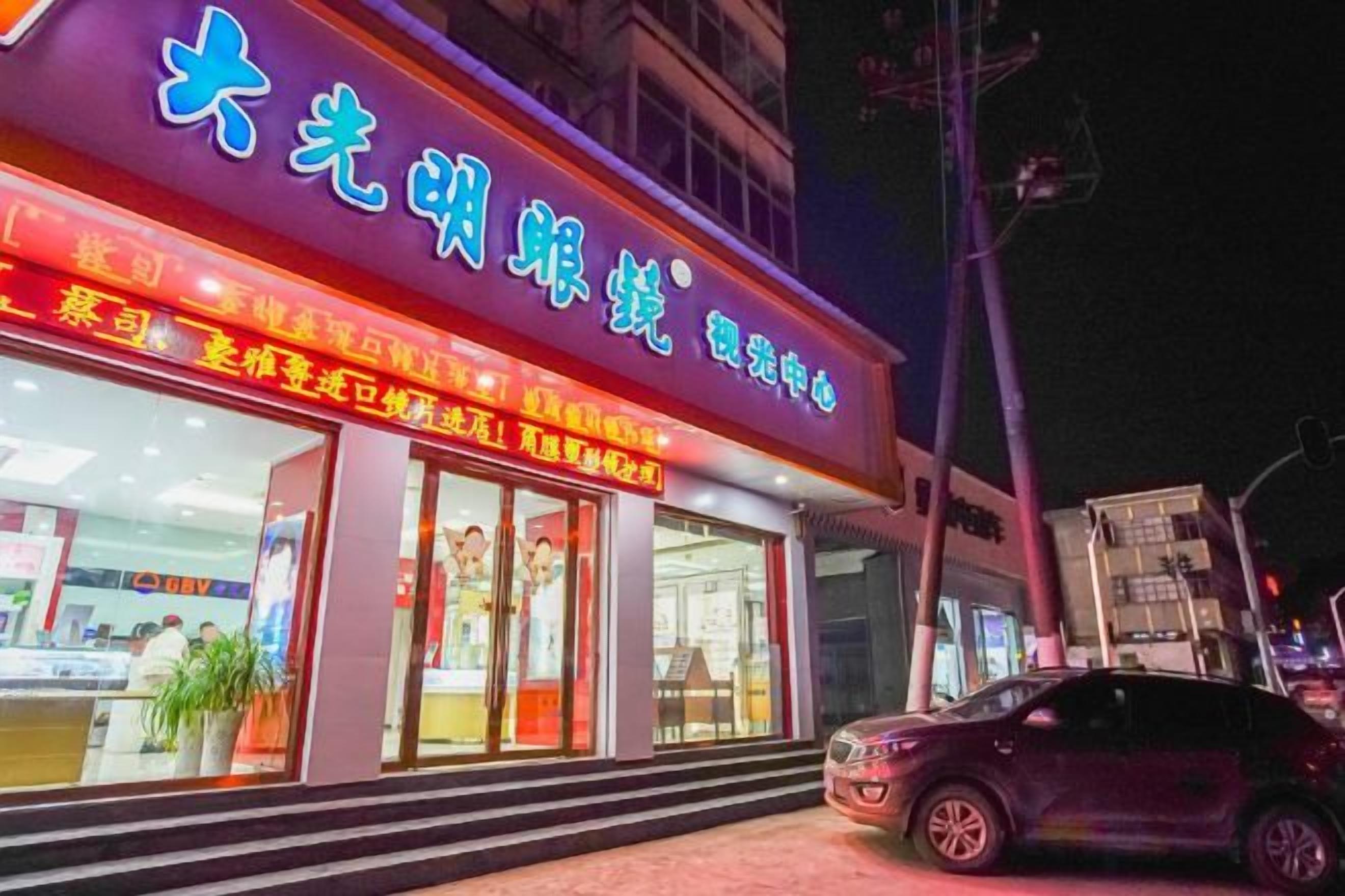 A building with a brightly lit sign and a visible entrance.