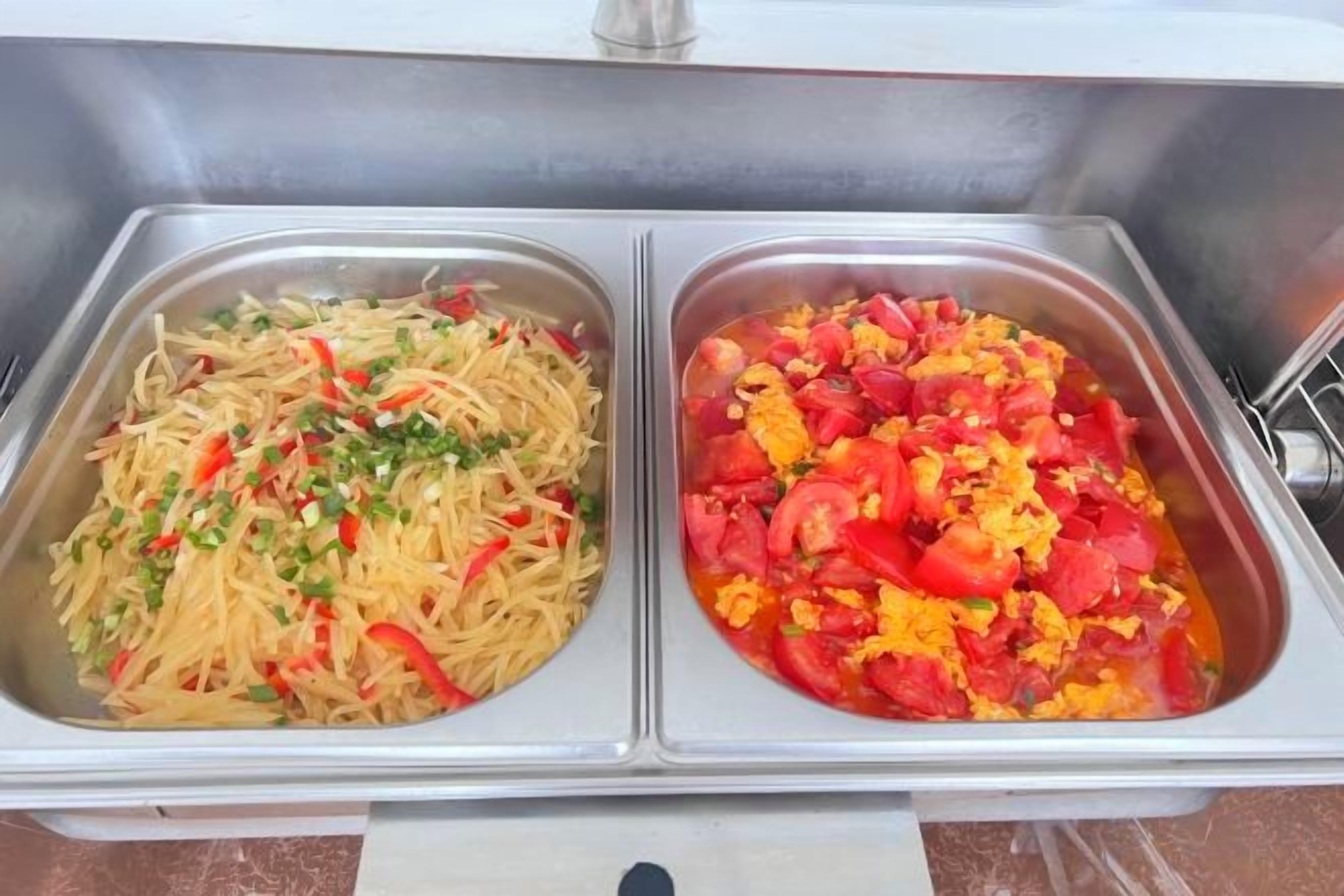 A stainless steel buffet with two food containers.