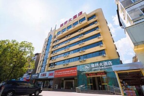 A multi-story hotel with a prominent sign for the LONGQIA HOTEL. - Longqiao Hotel (Yichang Yiting Three Gorges Airport) (Yichang)