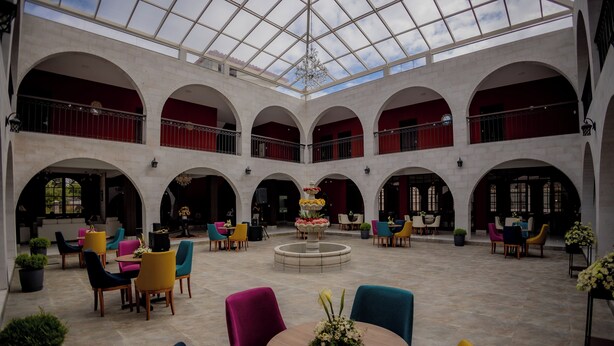 A spacious atrium with a high ceiling, multiple arches, and a central fountain.