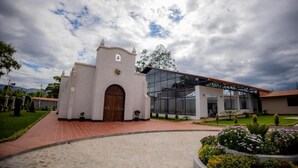 A building with a traditional architectural style, featuring a central arched entrance and a modern extension with large glass windows.