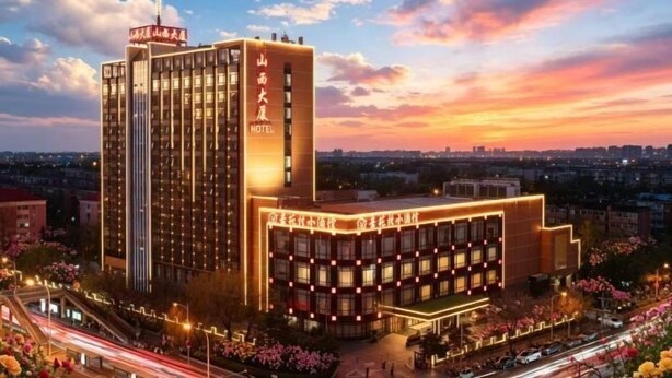 A multi-story hotel with a prominent entrance and a large building facade.