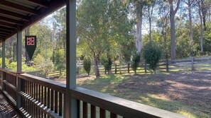 Enjoy a serene view of the surrounding grassy field and trees from this outdoor deck.