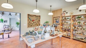 Una tienda de cerámica con estantes llenos de alfarería y una mesa de exhibición en el centro.