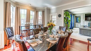 Un coin repas avec une table en marbre, des chaises en cuir et un vase de fleurs.