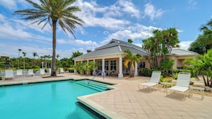 A swimming pool with lounge chairs and palm trees. - Walk to Stuart Beach: Resort Condo w/ Water View! (Stuart)