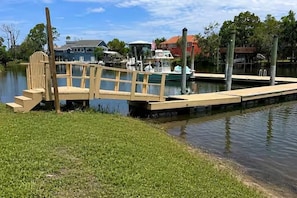 A wooden dock extending into calm water with a grassy bank on one side. - Sleeps 6. Kayaks. Boat Dock. Big Yard (Crystal River)