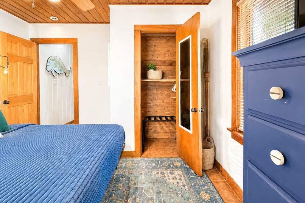 Une chambre à coucher avec un lit, une porte en bois et une armoire.
