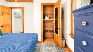 Une chambre à coucher avec un lit, une porte en bois et une armoire.