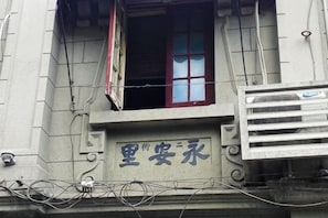 Ein Gebäude mit einem Schild, auf dem '里安永' steht, und einem Fenster mit roten Vorhängen.