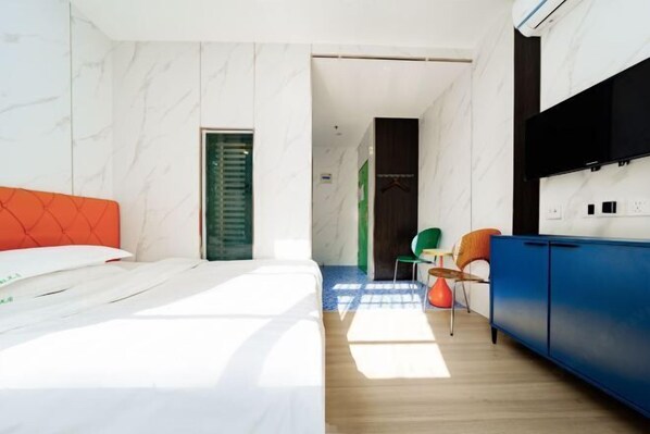 Ein modernes Hotelzimmer mit einem Bett, einem blauen Schrank und einem grünen Sessel.