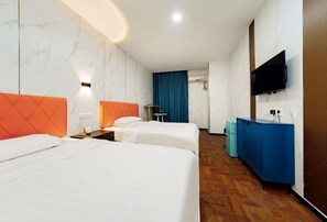 Une chambre d’hôtel avec deux lits, un mini-bar bleu, une télévision et une salle de bain avec un rideau bleu.
