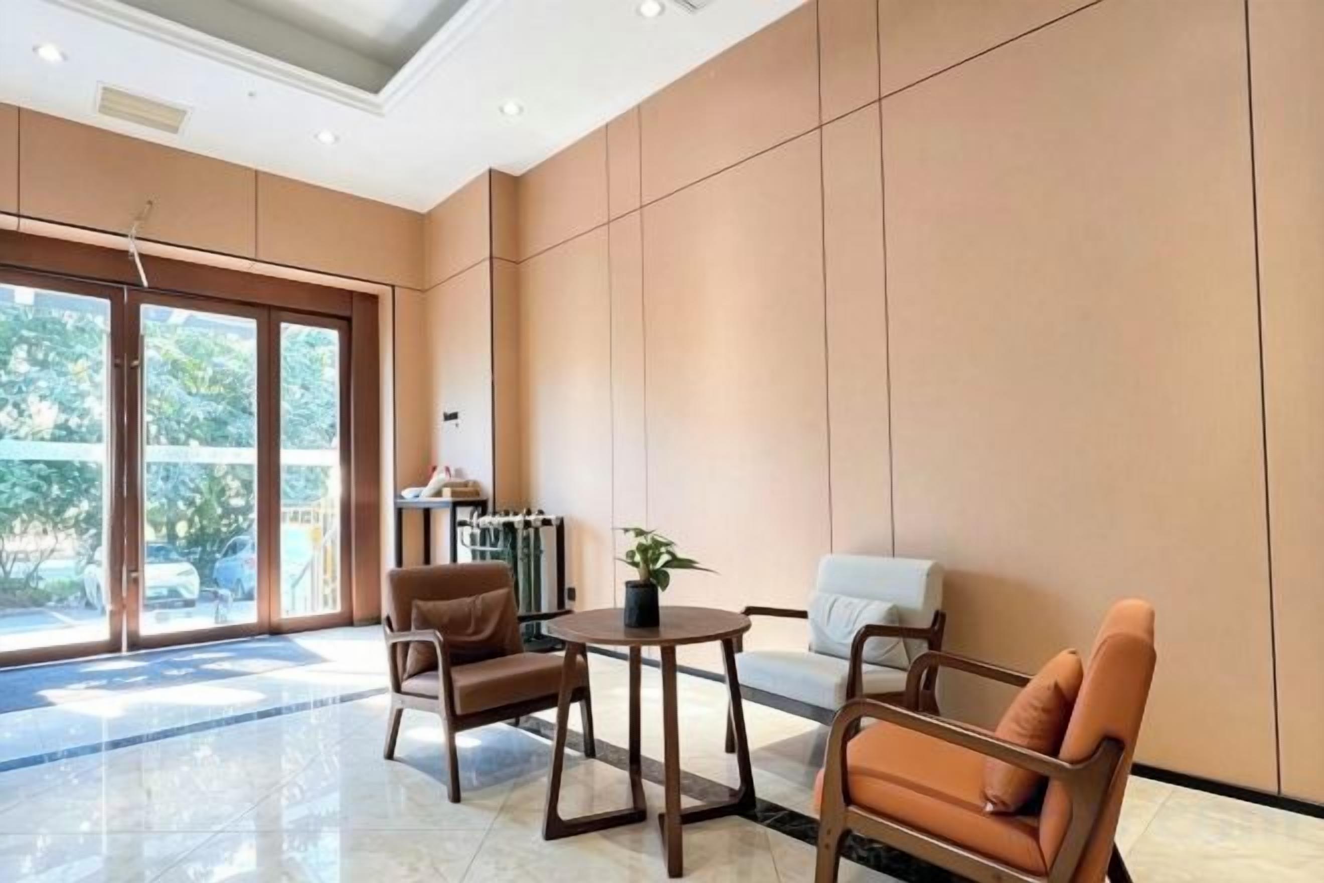 Un vestíbulo de hotel con zona de estar, mostrador de recepción y un amplio ventanal.