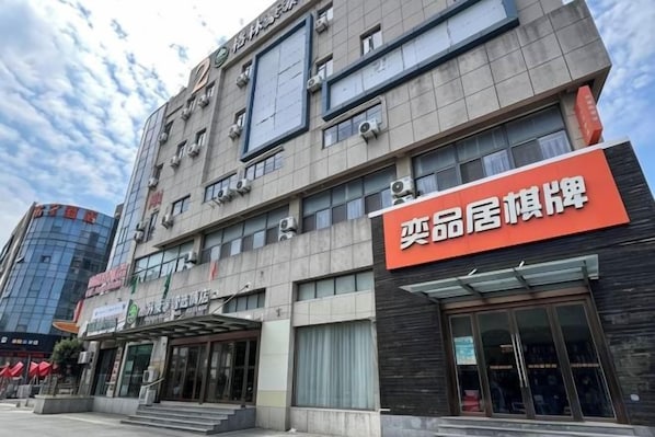 Un edificio de varios pisos con escaparate y un cartel llamativo.