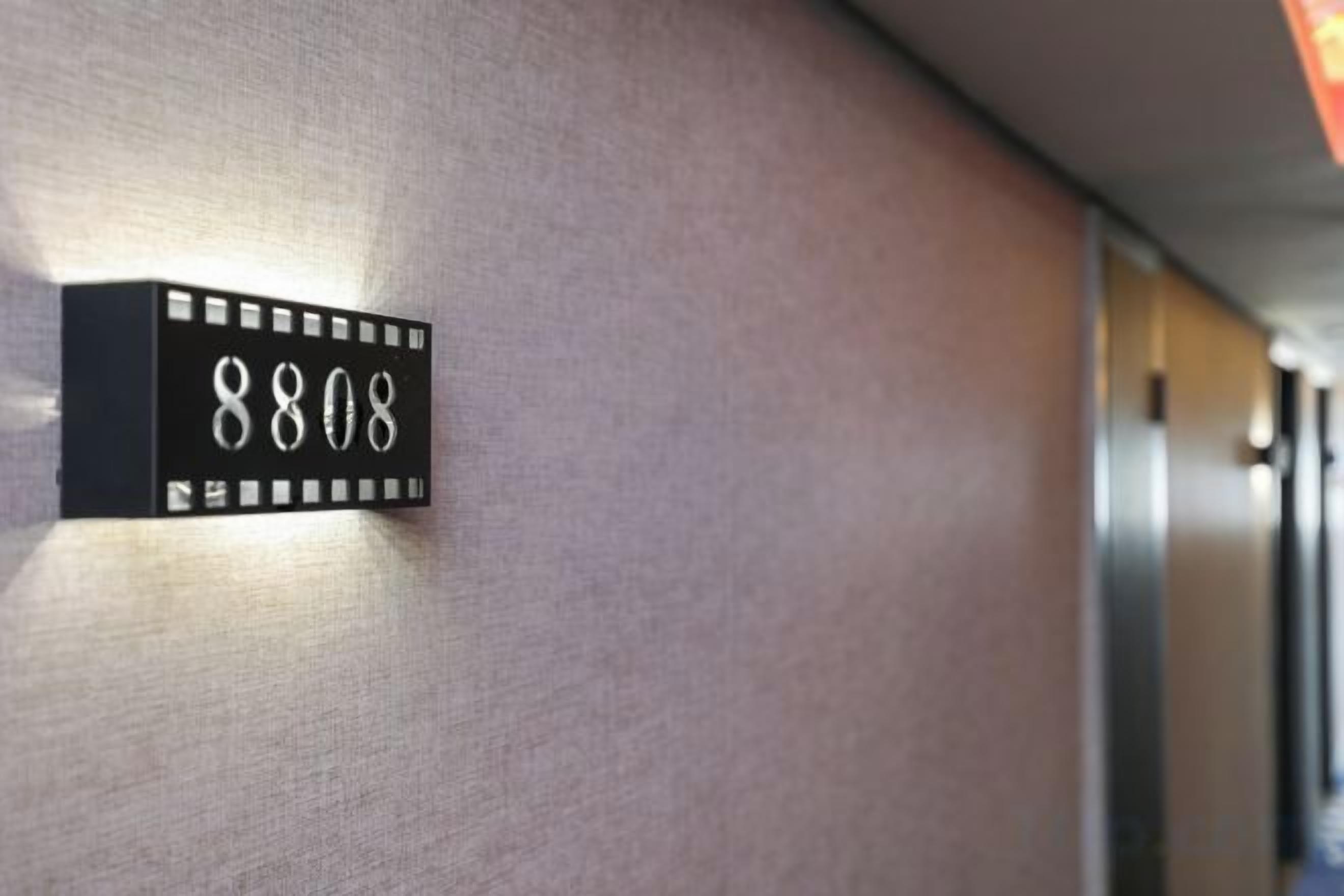 Ein an der Wand befestigtes Schild mit der Nummer 8808, das einen Raum oder Ort kennzeichnet.