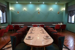 A conference room with a long table, red chairs, and a teal wall. - Jupian Movie Hotel (Pingyang Aojiang Xinhenan Road) (Pingyang)