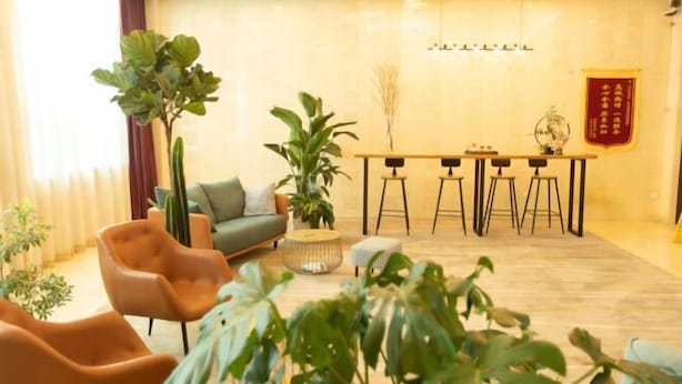 A modern living room with a sofa, chairs, a coffee table, and a dining area with stools. - Shanshui Trends Hotel (Beijing Capital International Airport Xinguozhan) (Beijing)