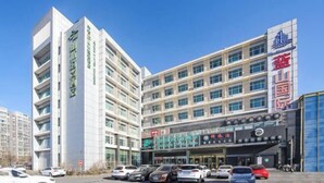A multi-story hotel with a modern facade, featuring a prominent entrance with signage and a parking lot in front. - Shanshui Trends Hotel (Beijing Capital International Airport Xinguozhan) (Beijing)