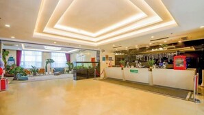 A hotel lobby with a reception desk, seating area, and a glass wall providing a view of the outdoors. - Shanshui Trends Hotel (Beijing Capital International Airport Xinguozhan) (Beijing)