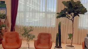 A room with two orange chairs, a tall cactus, and a potted plant. - Shanshui Trends Hotel (Beijing Capital International Airport Xinguozhan) (Beijing)