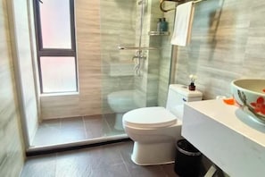 A bathroom with a glass shower enclosure, a toilet, and a sink with a decorative bowl. - Film and Television Youth Hotel (Shanghai Chefeng Road) (Shanghai)