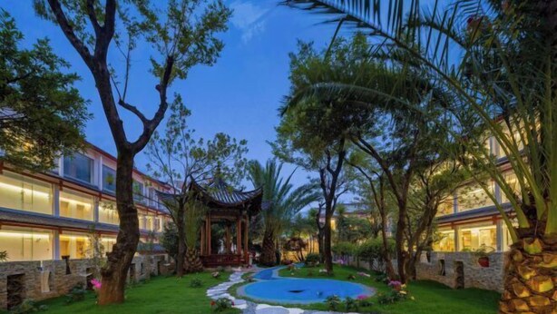 A well-maintained garden with a central water feature, surrounded by lush greenery and stone pathways.