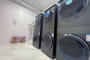 A row of stacked washing machines in a commercial setting. - Jia Li Da Garden Hotel (Lijiang)