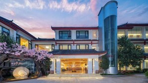 A traditional building with a modern glass tower, a welcoming entrance, and cherry blossoms.