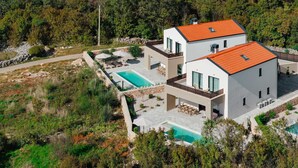 A modern two-story house with a swimming pool, surrounded by natural landscape. - Villa DIVA I with private pool (Kras)