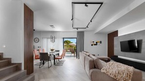 A modern living room with a sofa, TV, and staircase. - Villa DIVA I with private pool (Kras)