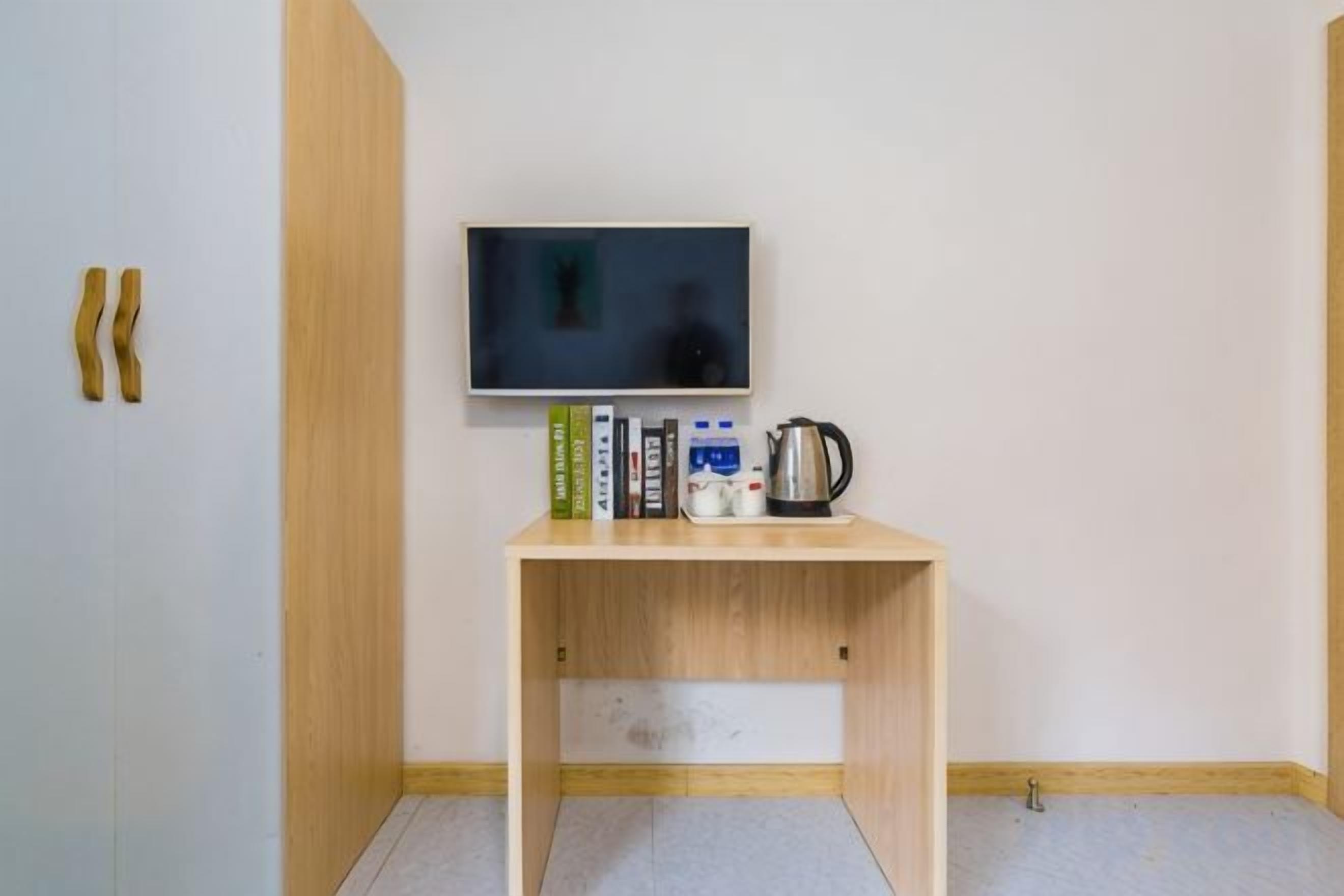 Ett litet rum med ett träbord, en tv och några böcker.
