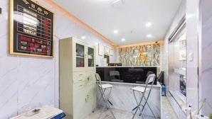 A modern kitchen with a marble countertop, two bar stools, and a digital menu board. - Ping'an Hotel (Shanghai)