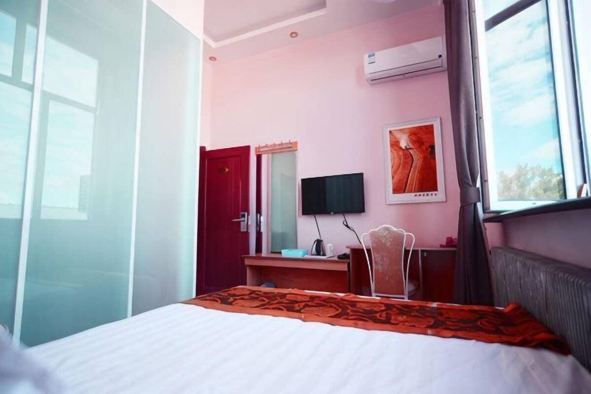 Une chambre d’hôtel équipée d’un lit, d’un bureau, d’une télévision et d’un appareil de climatisation.