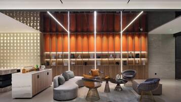 A modern interior with a reception desk, seating area, and a wall with illuminated panels.