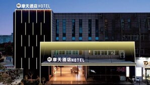 A hotel with a modern facade, featuring a prominent entrance with a glass door and a sign above it. - Skyscraper Hotel (Wenling Jingyuan Branch) (Wenling)