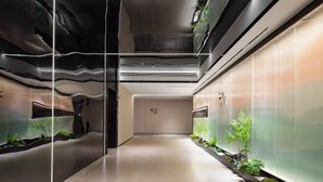 A modern hallway with a glass wall, a reception desk, and a clock. - Skyscraper Hotel (Wenling Jingyuan Branch) (Wenling)