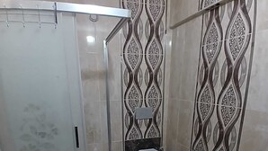 Ein Badezimmer mit Duschkabine, Toilette und Waschbecken.