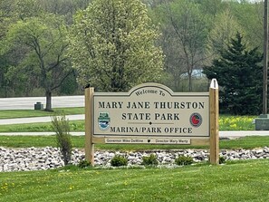 Willkommensschild für den Mary Jane Thurston State Park mit dem Logo der Ohio State Parks, einem Hafen/Parkamt sowie Erwähnungen von Gouverneur Mike DeWine und Direktorin Mary Mertz.