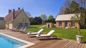 A poolside area with lounge chairs and a wooden deck. - Casa Pertica  (Ceton)