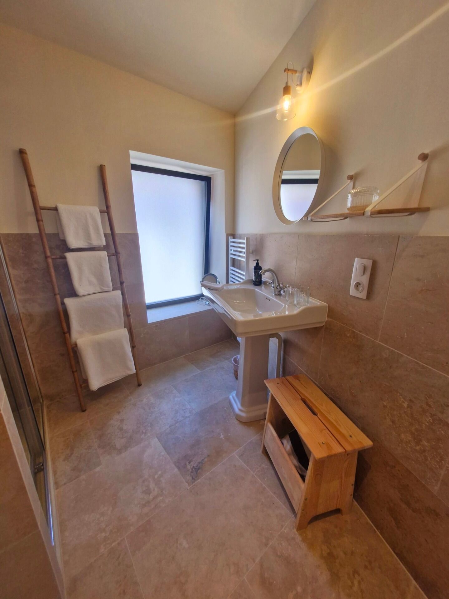 A bathroom with a bathtub, a sink, a mirror, and a window.