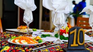 Una mesa de comedor con mantel colorido, servilletas blancas y un cartel con el número 10.