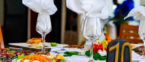 A dining table with a colorful tablecloth, white napkins, and a number '10' sign.