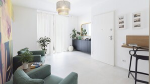A modern living room with a sofa, a coffee table, and a dining area with a bar stool. - DOMO CICINDELA (Carloforte)